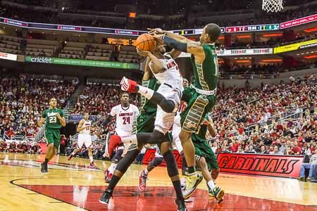 Russ Smith gets fouled by Anthony Collins on the way to the basket.