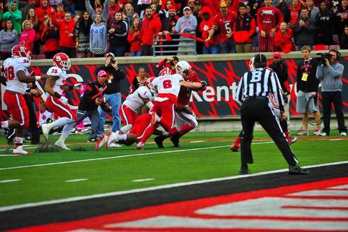 Michael Dyer carries most of the Wolfpack toward the end zone.