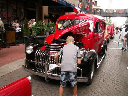 A young boy buffs the chrome on this classic fire truck.