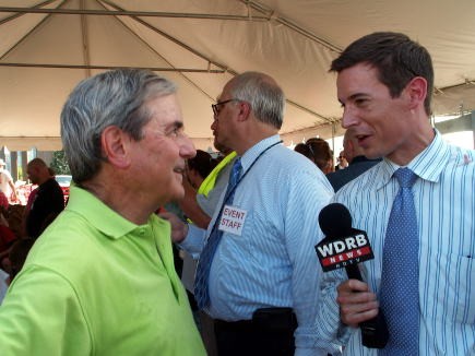WDRB newsreader Bennent Haeberle interviewing Rep. Yarmuth while the children dig.