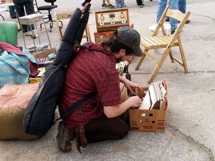 A musician combing through some vinyl for inspiration.