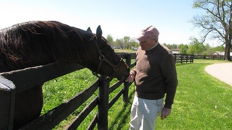 Old Friends Founder, Michael Blowen, feeds Thoroughbred resident Afternoon Deelites a carrot.