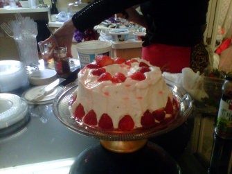 Angel food cake topped with whipped cream, strawberries and strawberry liqueur.