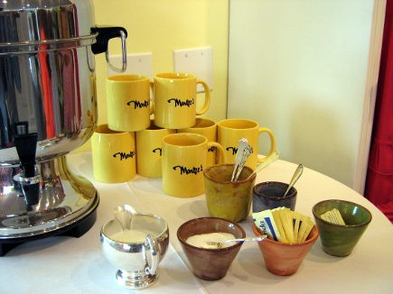 Branded coffee mugs await to be filled.
