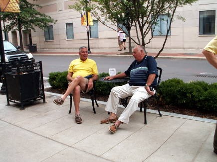 Two gentlemen take a seat in front of Les Filles Louisville between visits to the shops in SoFo.